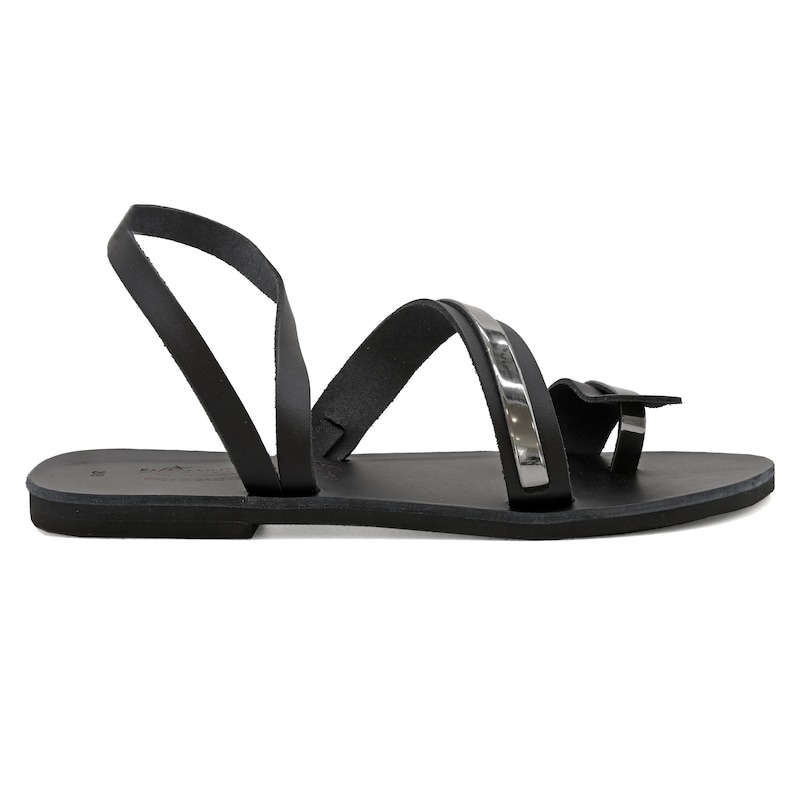 May include: Black leather sandals with a silver strap and a toe loop.