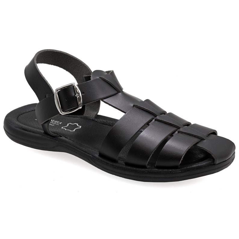 Op de afbeelding: Zwarte leren sandalen met een gespsluiting en een geweven band ontwerp. De sandalen hebben een platte zool.