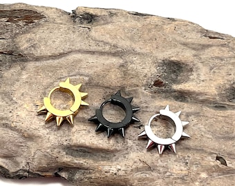 May include: Three pairs of small hoop earrings with spikes. The earrings are gold, silver, and black.
