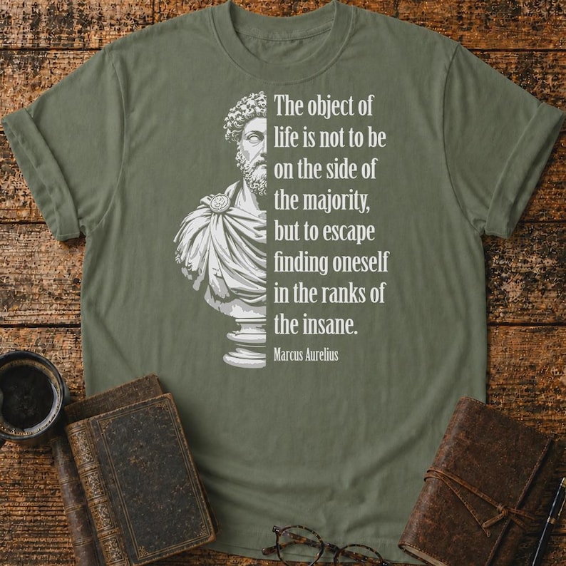 May include: An olive green t-shirt featuring a white graphic of a Marcus Aurelius bust on the left and the text: The object of life is not to be on the side of the majority, but to escape finding oneself in the ranks of the insane. Marcus Aurelius.