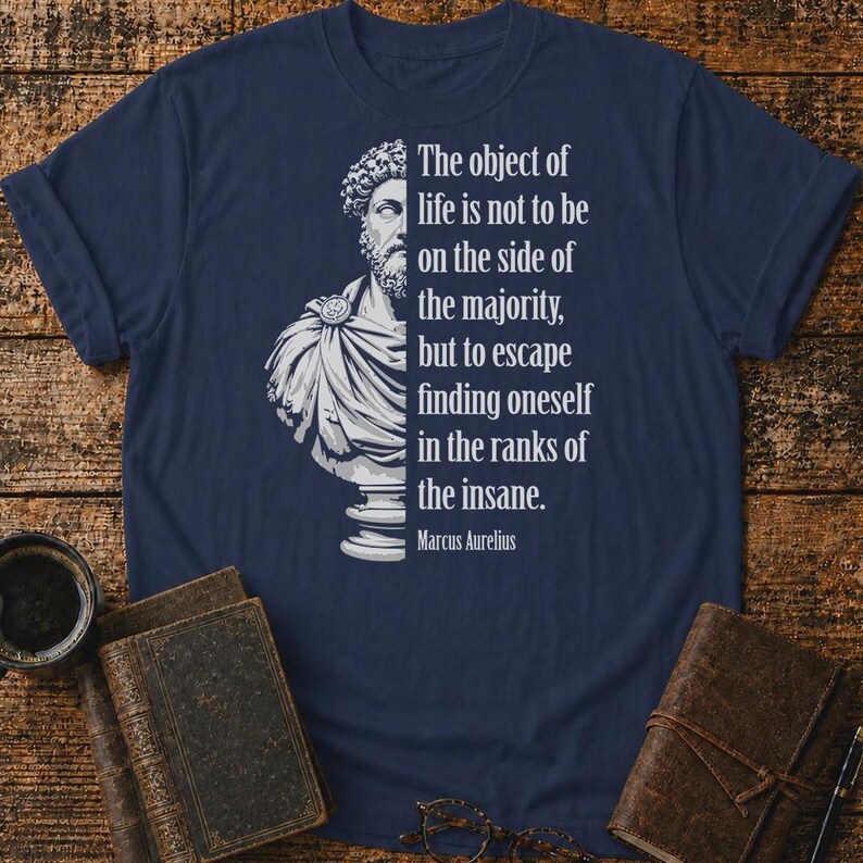 May include: A navy blue t-shirt featuring a white graphic of a Marcus Aurelius bust on the left side and the quote: The object of life is not to be on the side of the majority, but to escape finding oneself in the ranks of the insane. Marcus Aurelius.