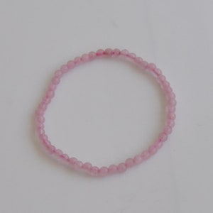 Op de afbeelding: Een delicate roze kralen armband gemaakt met kleine, ronde kralen. De armband is simpel en elegant, perfect voor dagelijks gebruik.