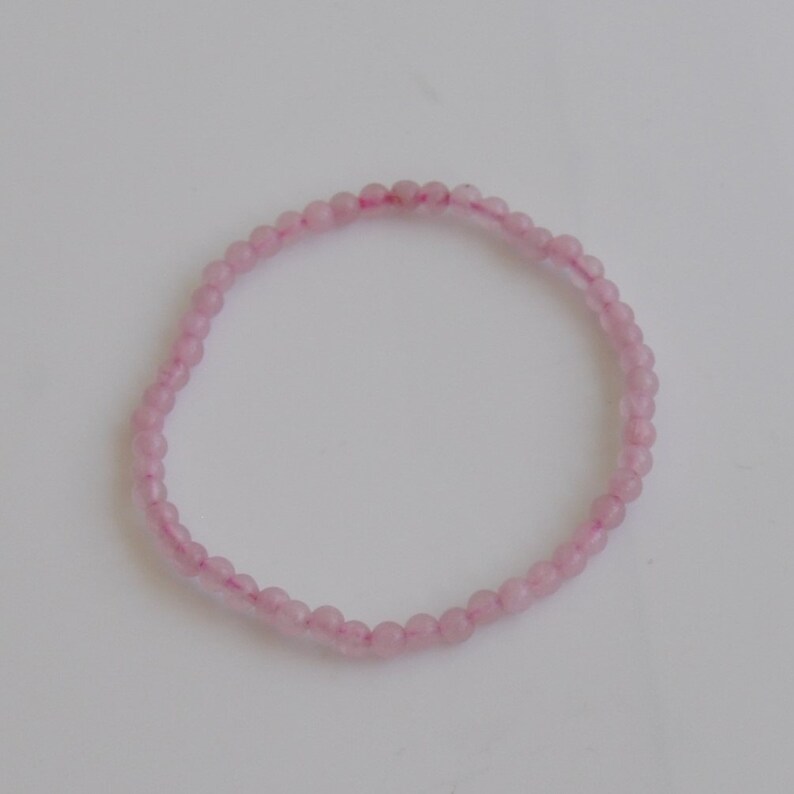Op de afbeelding: Een delicate roze kralen armband gemaakt met kleine, ronde kralen. De armband is simpel en elegant, perfect voor dagelijks gebruik.
