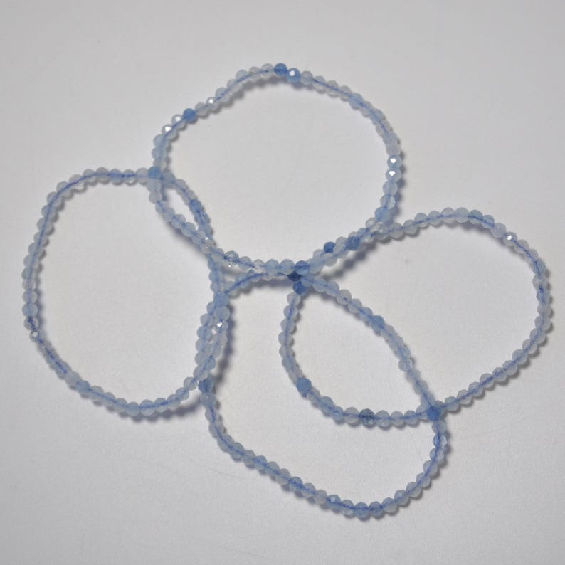 May include: Four light blue beaded bracelets made of faceted gemstone beads.