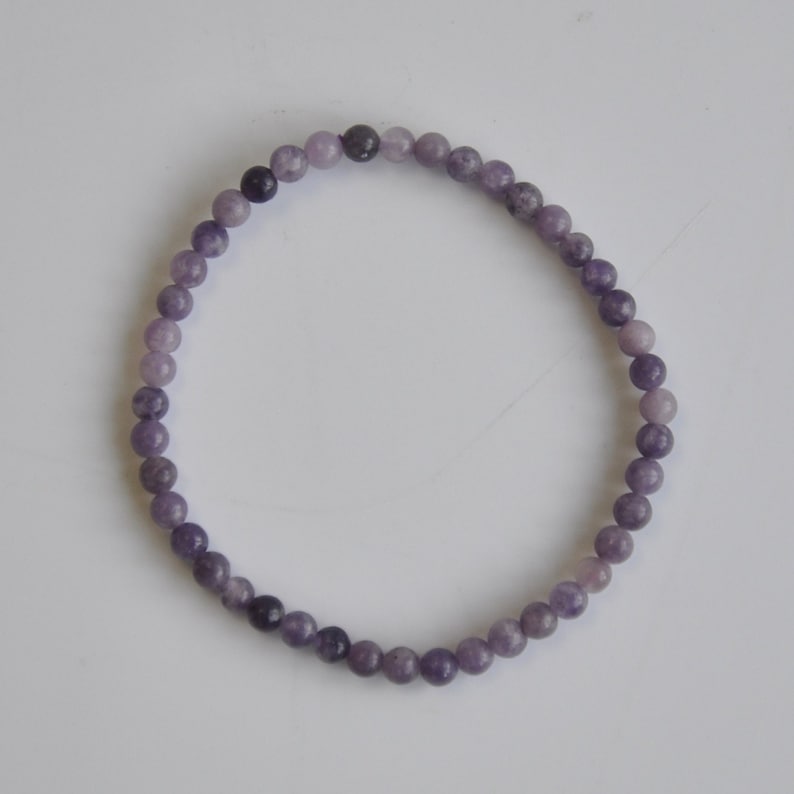 Puede incluir: Un brazalete de piedras preciosas de color p&uacute;rpura con cuentas redondas.