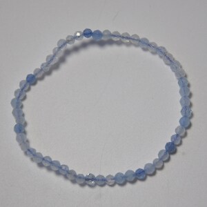 May include: A delicate bracelet made of light blue gemstone beads. The beads are faceted and have a subtle shimmer.