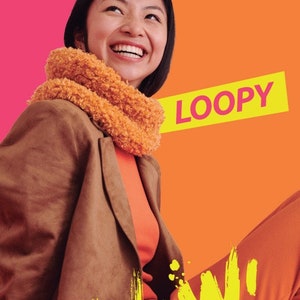 Puede incluir: Una mujer con una chaqueta marrón, un jersey de cuello alto naranja y una bufanda naranja esponjosa sonríe a la cámara. El fondo es de color dividido en rosa y naranja. El texto "LOOPY" está en amarillo sobre fondo negro. El texto "Now!" está en amarillo sobre fondo naranja.