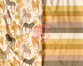 May include: A white fabric with a repeating pattern of brown horseshoes, stars, and horses. The horses are in various poses, including running, standing, and jumping. The fabric has a light brown, beige, and white striped pattern on the right side.