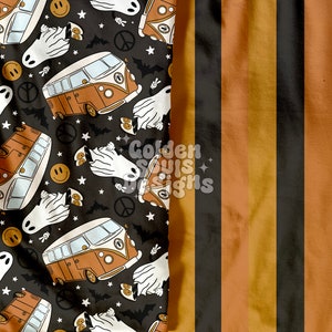 May include: A black and white striped fabric with orange stripes. The fabric has a pattern of vintage vans, ghosts, peace signs, and smiley faces.