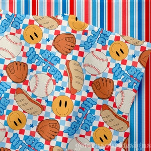 Peut inclure: Un tissu à carreaux blancs et bleus avec une bordure rayée rouge et bleue. Le tissu présente un motif répétitif de balles de baseball, de hot-dogs, de visages souriants, de gants de baseball et le texte "BIG HITTER".