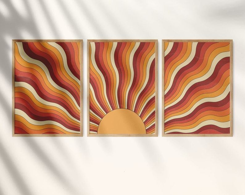 May include: Three framed prints with a retro sunburst design. The sunburst is made up of orange, red, and yellow wavy lines. The center of the sunburst is a solid yellow circle.