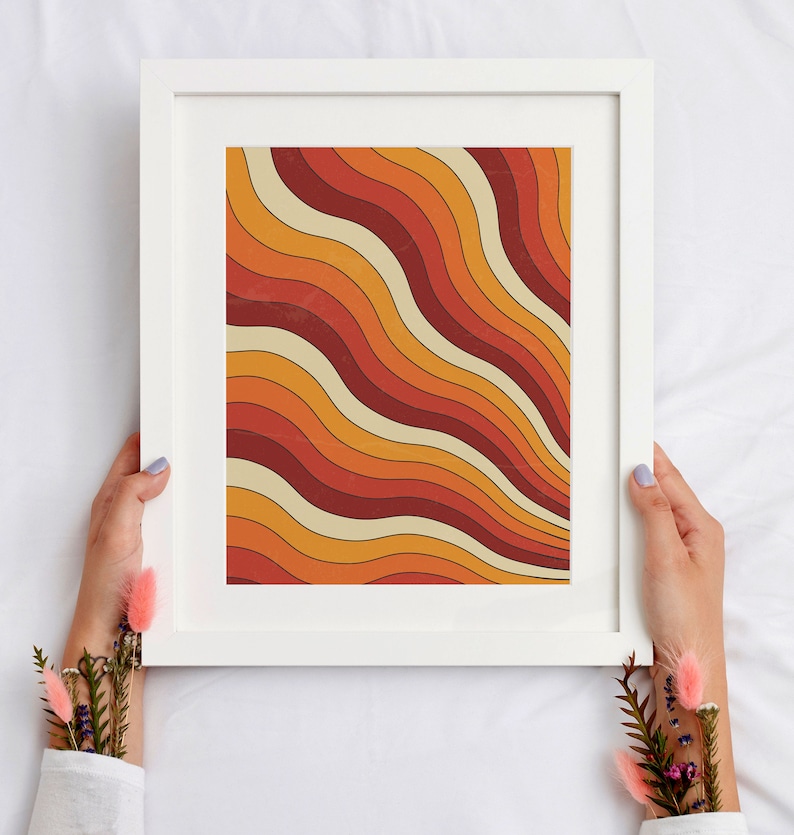 May include: A framed print with a retro abstract design featuring wavy lines in shades of orange, red, and cream.