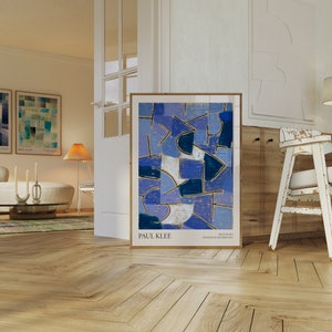 Op de afbeelding: Een ingelijste abstracte kunstprint van Paul Klee met de titel "Blue Night" uit het Museum of Modern Art. De print heeft een geometrisch ontwerp in tinten blauw, paars en wit.