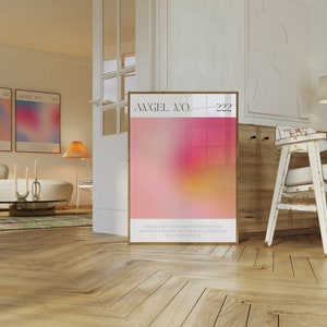 May include: A framed poster with a pink and yellow gradient background. The poster has the text "ANGEL NO. 222" and a quote about angels. The poster is hanging on a white wall in a room with wooden floors.