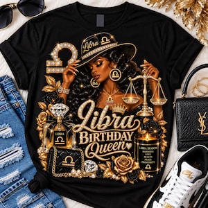 May include: A black t-shirt featuring a graphic of a person wearing a hat with the text Libra, holding a golden scale. The design includes a perfume bottle, a quilted handbag, a candle with the text Libra Season Harmony Love Peace Prosperity, and gold roses.