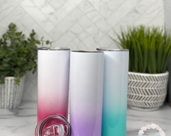 Puede incluir: Tres vasos de acero inoxidable con un diseño de degradado de color. Los vasos son de color rosa, morado y turquesa. Los vasos están sobre una encimera blanca.