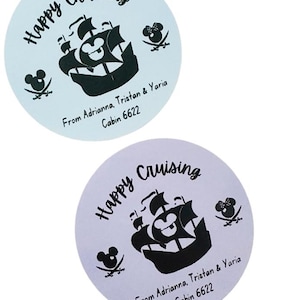 May include: Two round stickers with a light blue and light purple background. The stickers feature a black silhouette of a ship with Mickey Mouse ears on the sail. The text "Happy Cruising" is written in a cursive font. The stickers also include the text "From Adrianna, Tristan & Yaria" and "Cabin 6622".