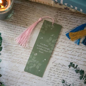 Puede incluir: Un marcap&aacute;ginas verde con un borla rosa. El marcap&aacute;ginas tiene un dise&ntilde;o de hojas y el texto "Para aquellos que son lo suficientemente valientes para seguir su coraz&oacute;n."