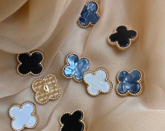 Botones florales de diseño exclusivo con incrustaciones de nácar, disponibles en negro, blanco leche y grafito.