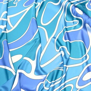 May include: Blue and white abstract patterned fabric with a silky texture.