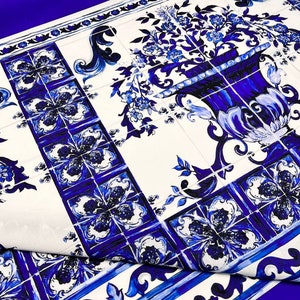 May include: Blue and white patterned fabric with a floral design. The fabric features a repeating pattern of blue and white tiles with a floral motif. The fabric is perfect for crafting, quilting, and home decor projects.