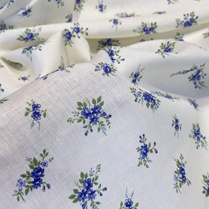 Pu&ograve; includere: Tessuto bianco con un piccolo motivo floreale blu. Il tessuto ha una trama di lino.
