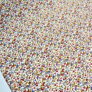 May include: White fabric with a small floral print in shades of red, blue, and yellow.