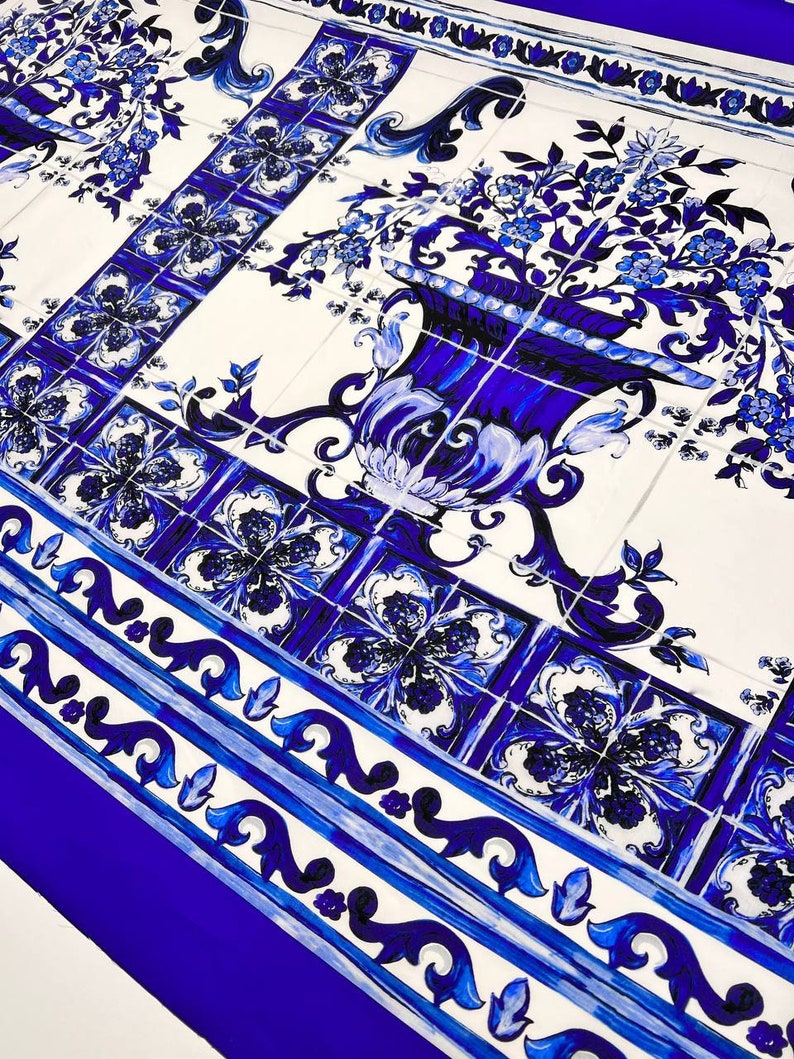 May include: Blue and white patterned fabric with a repeating design of flowers and a vase. The fabric has a blue border with a white and blue pattern.