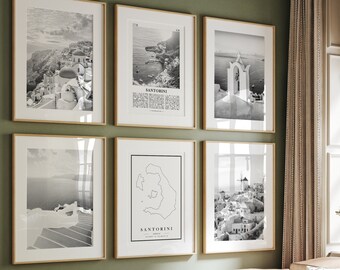 May include: A set of six black and white framed prints featuring various scenes of Santorini, Greece. The prints are arranged in a grid pattern on a green wall. The prints include a view of the town, a map of the island, and a close-up of a church.