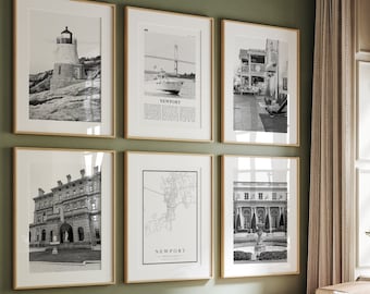 May include: A living room with a light green wall and a light brown leather sectional sofa. The sofa has a green throw pillow and a black and white patterned throw pillow. There are six black and white framed pictures on the wall above the sofa. The pictures are of various buildings and landmarks. There is a small round table in front of the sofa with a book and a vase of white flowers on it. There is a woven basket on the floor next to the sofa.