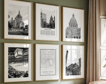 May include: A living room with a green wall and a light brown couch. There are six black and white framed pictures on the wall, including a map of Saint Paul, Minnesota. The pictures are all in wooden frames.