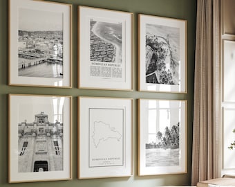Op de afbeelding: Een set van zes zwart-wit ingelijste prints met afbeeldingen van de Dominicaanse Republiek. De prints bevatten een kaart van het land, een stadsbeeld, een strandscène en een palmboombos. De prints worden weergegeven op een groene muur boven een lichtbruine bank met een groen kussen en een gestreept dekbed.