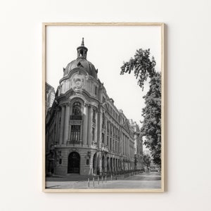 Puede incluir: Fotograf&iacute;a en blanco y negro de un gran edificio adornado con una torre de reloj. El edificio se encuentra en una calle con &aacute;rboles y otros edificios en el fondo.