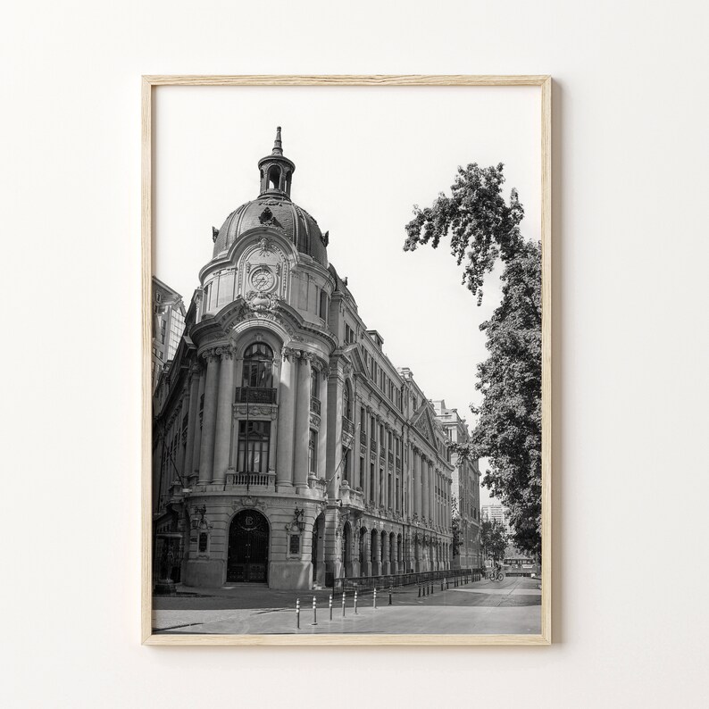 Puede incluir: Fotograf&iacute;a en blanco y negro de un gran edificio adornado con una torre de reloj. El edificio se encuentra en una calle con &aacute;rboles y otros edificios en el fondo.