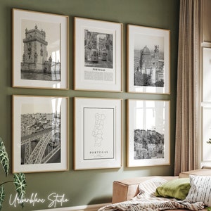 May include: A set of six black and white framed prints featuring various images of Portugal, including a map, a bridge, a tram, and a building. The frames are a light wood colour and are arranged in a grid pattern on a green wall.