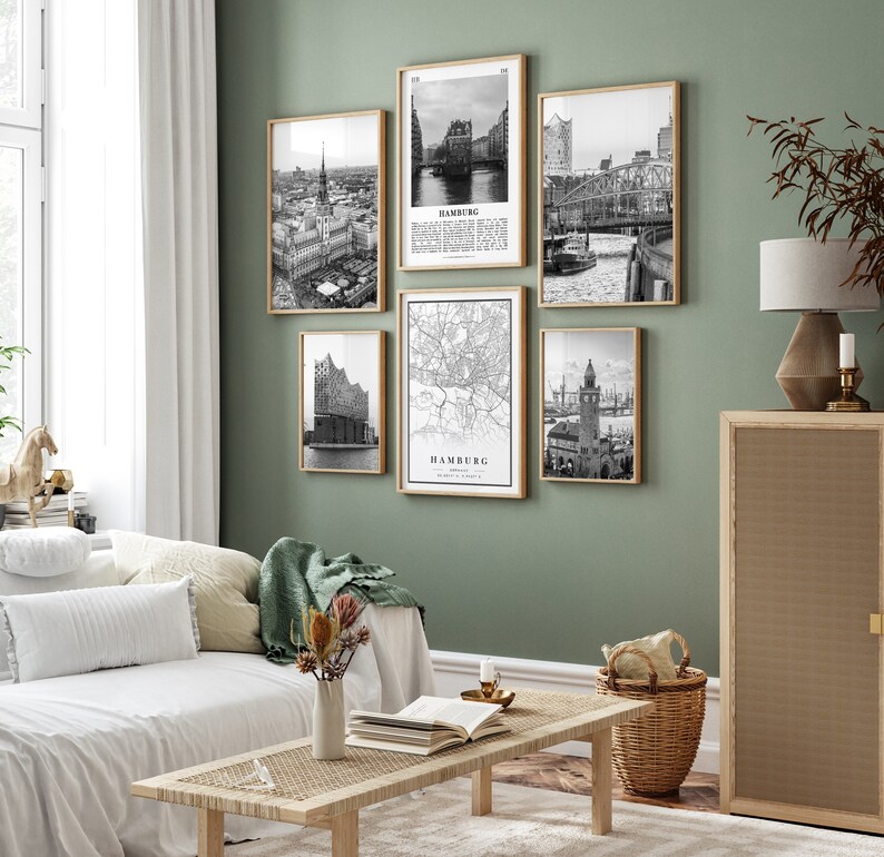 May include: A set of five black and white framed prints featuring various images of Hamburg, Germany. The prints are arranged in a grid pattern on a green wall. The prints include a map of Hamburg, a view of the city skyline, and a view of the Elbe River.