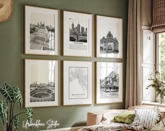 May include: A set of six black and white framed prints featuring various architectural landmarks in Melbourne, Australia. The prints are arranged in a grid pattern on a green wall. The prints include a view of the city skyline, a bridge, a building with a dome, a stadium, a map of the city, and a building with a unique design.