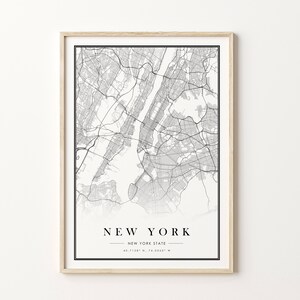 May include: Framed black and white map print of New York City and New York State. The map shows detailed street layouts and geographical features. The print includes the text "NEW YORK" and coordinates.