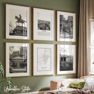 Puede incluir: Una pared de galería con seis fotografías en blanco y negro enmarcadas de diferentes escenas en Sendai, Japón. Las fotos incluyen una estatua de un samurái a caballo, un paisaje urbano, una puerta japonesa tradicional, un mapa de la ciudad, un edificio y un parque.