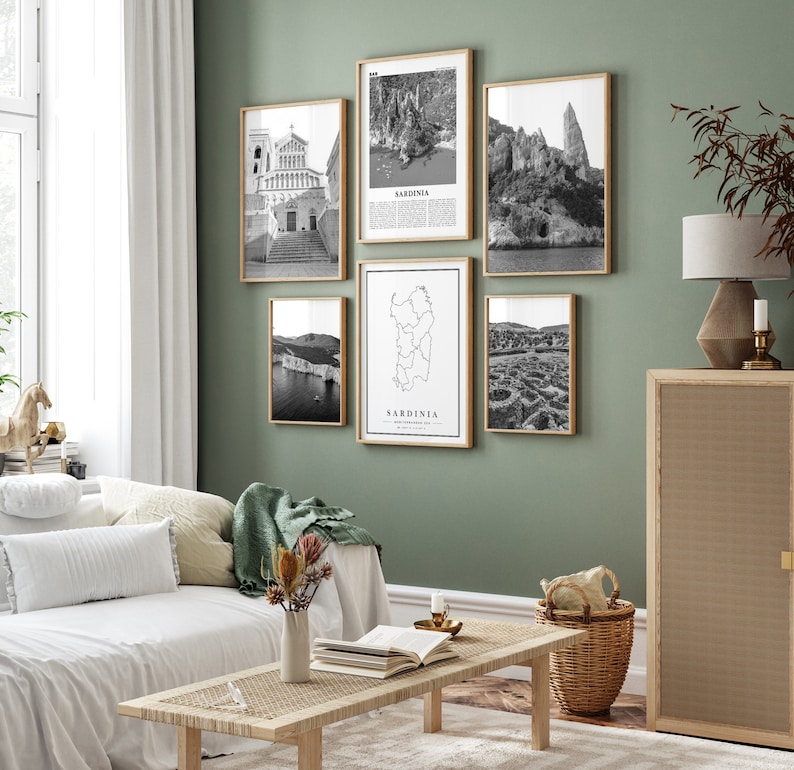 May include: A set of six black and white framed prints featuring images of Sardinia, Italy. The prints include a map of Sardinia, a church, a cliffside, and a view of the coastline. The prints are arranged in a grid pattern on a green wall.