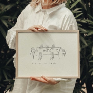 Könnte beinhalten: Ein gerahmter Druck mit einer Schwarzweißillustration eines Tisches mit Stühlen und dem Text "Sit at his table".