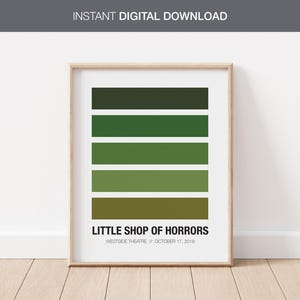 Puede incluir: Una impresión enmarcada con una paleta de colores de tonos verdes. La impresión tiene el título "Little Shop of Horrors" y el texto "Westside Theatre // October 17, 2019".