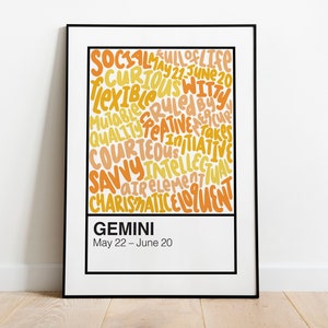 May include: A framed print with a white background and black frame. The print features a word cloud of personality traits associated with the Gemini zodiac sign, in orange, yellow, and peach colors. The text "GEMINI" and "May 22 - June 20" is printed in black at the bottom of the print.