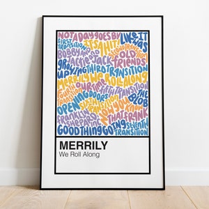 May include: A framed art print with the words "MERRILY We Roll Along" in a white box at the bottom. The artwork features colorful text in various fonts and sizes, including phrases like "NOT A DAY GOES BY" and "OPENING DOORS."