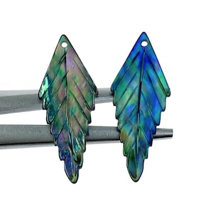May include: Two iridescent green and blue leaf-shaped pendants with a hole at the top for stringing.