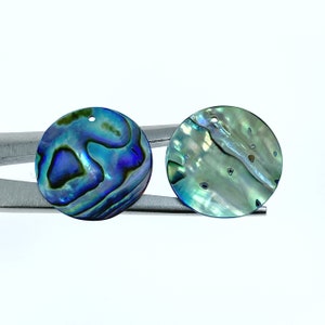 Peut inclure: Deux pendentifs ronds en nacre d'ormeau irisée avec un trou au centre pour la ficelle. Les coquilles ont un motif de couleur bleu, vert et violet.