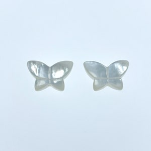 May include: Two white mother of pearl butterfly shaped embellishments.