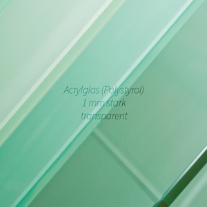 Könnte beinhalten: Nahaufnahme einer durchsichtigen Acrylglasscheibe, 1 mm dick. Der Text "Acrylglas (Polystyrol) 1 mm stark transparent" ist auf das Glas gedruckt.