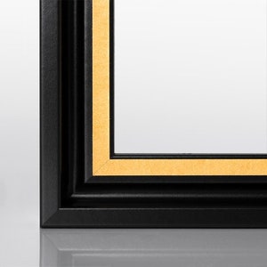 May include: A black picture frame with a gold inner lip. The frame has a simple, classic design.