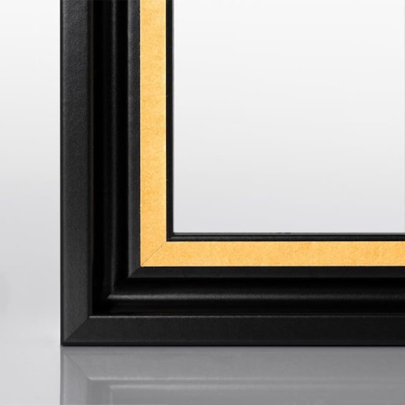 May include: A black picture frame with a gold inner lip. The frame has a simple, classic design.